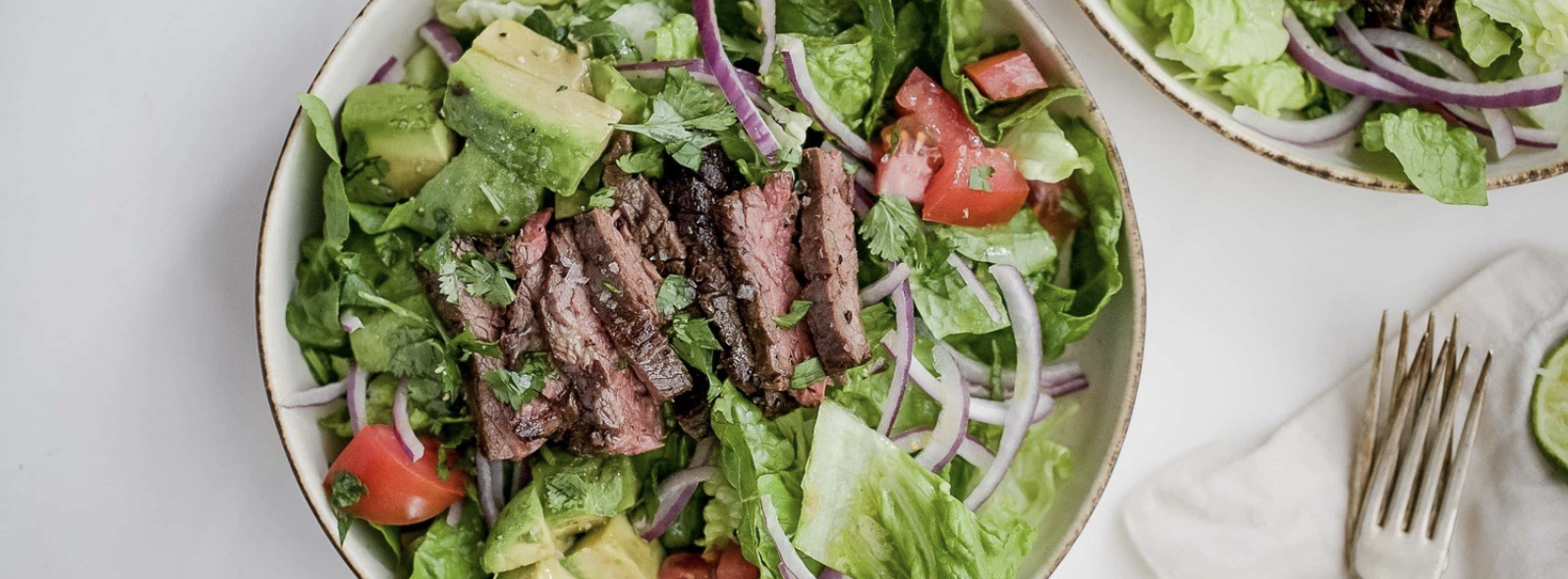 avocado and steak salad with red onions and tomatos
